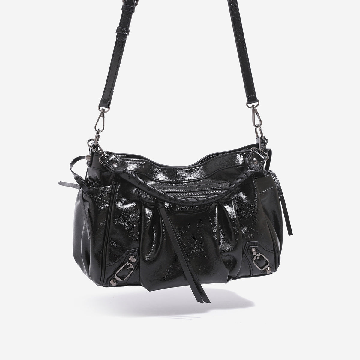 Slouchy glossy crinkle leather-look shoulder bag with silver stud accents, tassel ties, front zip pocket, and top handle