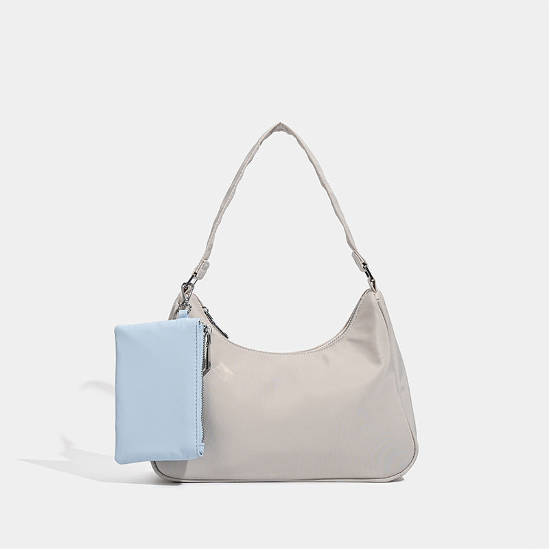 Curved hobo shoulder bag with detachable zip pouch in matte-satin finish with silver-tone hardware, front view