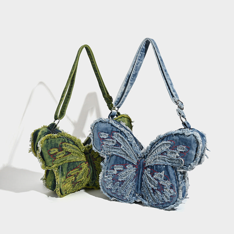 Butterfly-shaped distressed denim shoulder bag with frayed raw edges and embroidered wing panels, detail view 2