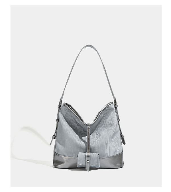 Lässig geformte Hobo-Schultertasche in Silbergrau mit holzmaserungsgeprägten Einsätzen, glänzender Metallic-Einfassung, Reißverschluss oben und vorderem Überschlag