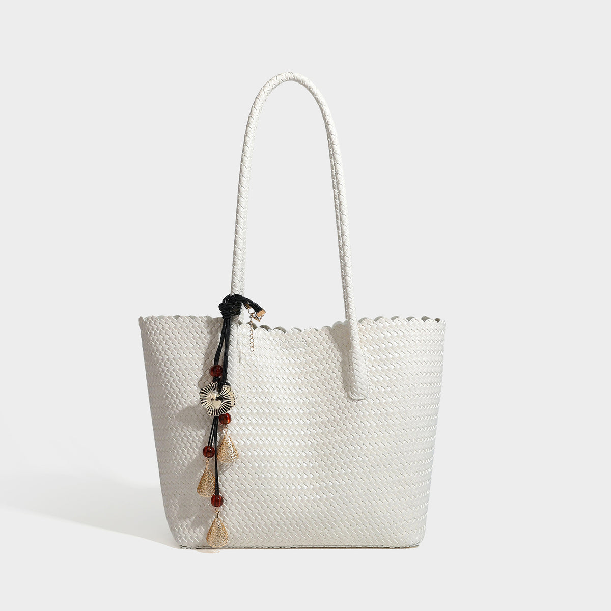 Large open-top woven leather-look tote bag in dark brown with scalloped edge, braided double shoulder straps, and decorative