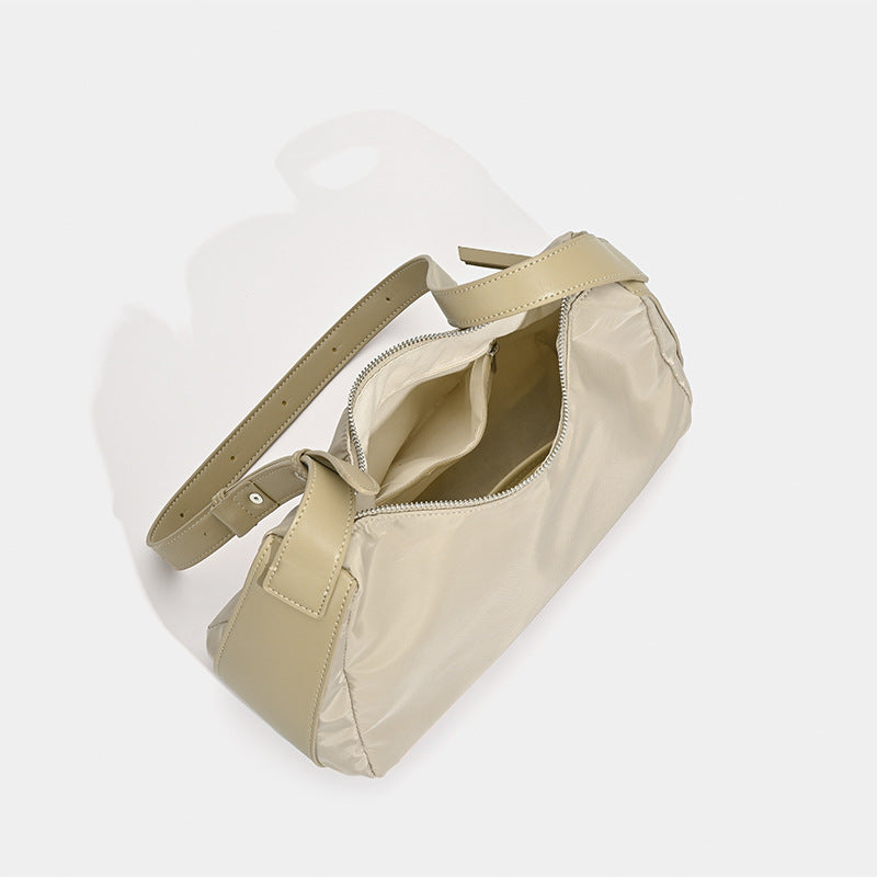 Soft crescent shoulder bag in smooth sheen nylon with contrast leather-look trim, slim adjustable strap, and top zip closure
