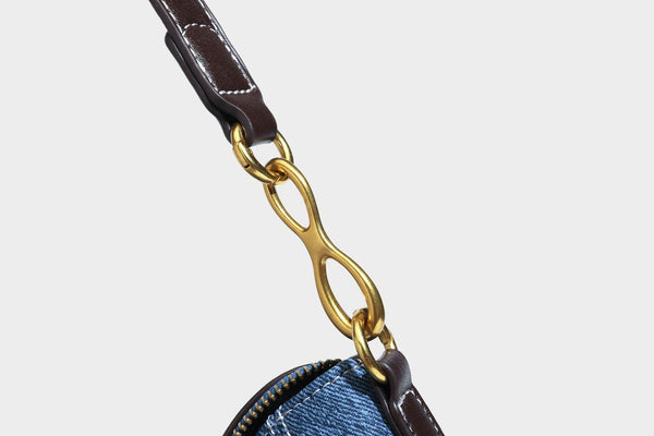 Slouchy denim shoulder bag with dark leather-look trim, gold-tone chain-link hardware, and top zipper closure, detail view 31