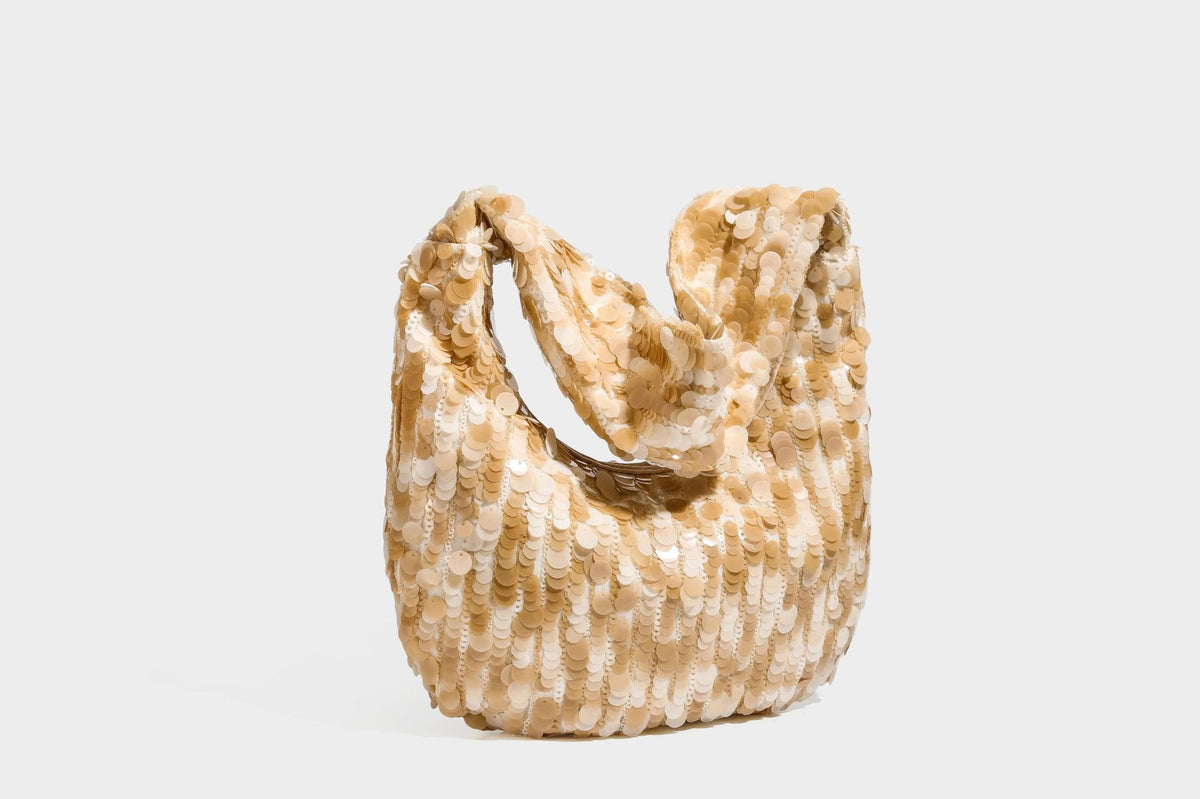 Slouchy crescent hobo shoulder bag covered in overlapping reflective sequin discs with a single integrated strap and top-zip