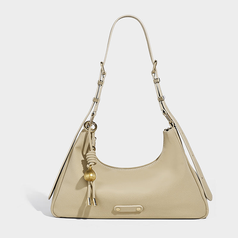 Crescent hobo shoulder bag in pebbled leather-look finish with top zipper, adjustable strap, gold-tone ring hardware, and