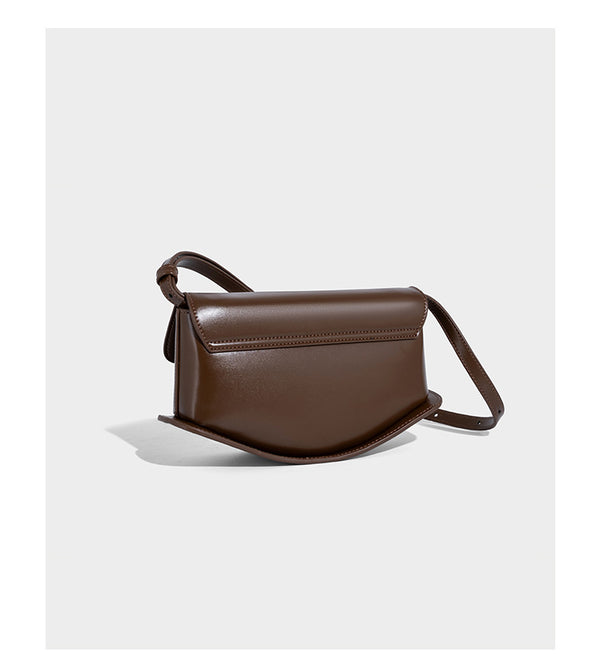 Small structured saddle bag with glossy leather-look finish, angular flap front, silver-tone metal clasp, and slim