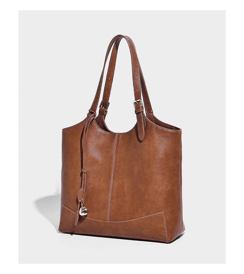 Große, strukturierte Schultertasche im Tote-Stil in Braun und Lederoptik mit langen Doppelriemen, Schnallenbeschlägen, Quasten-Anhänger und geschwungener
