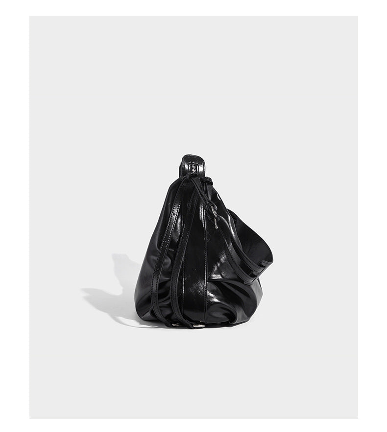 Glossy black slouchy hobo shoulder bag with zip closure, silver-tone ring hardware, and adjustable crossbody strap, detail