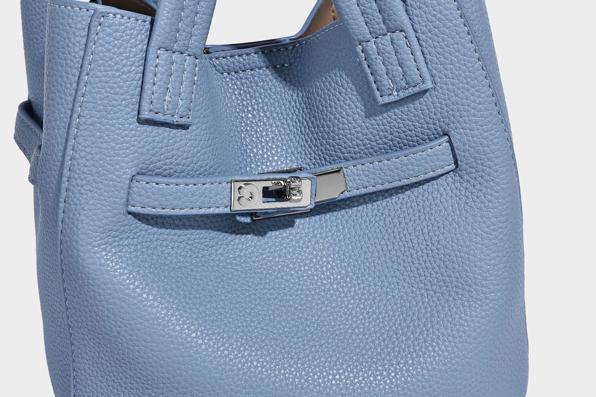 Small structured pebbled bucket tote bag with dual top handles, silver turn-lock front pocket, and detachable shoulder strap