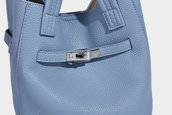 Small structured pebbled bucket tote bag with dual top handles, silver turn-lock front pocket, and detachable shoulder strap