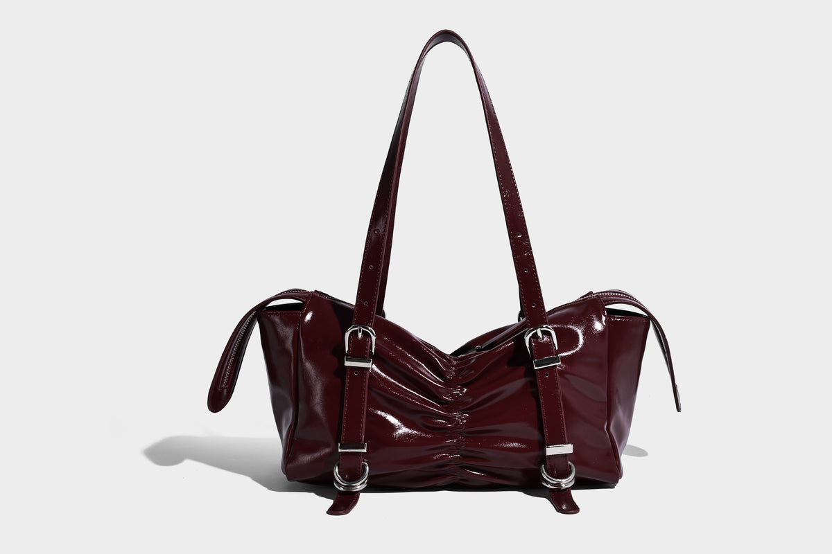 Glänzende, rechteckige Schultertasche mit Raffdetails, zwei verstellbaren Riemen, Reißverschluss oben und Schnallenbeschlägen in Silberoptik