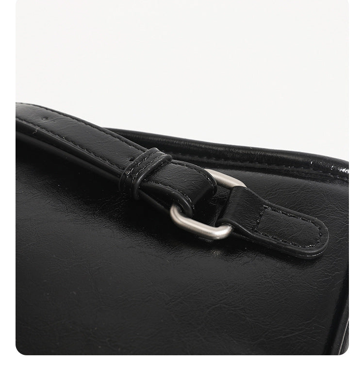 Structured glossy leather-look flap backpack handbag with dual buckle closures, top handle, and silver-tone hardware, detail
