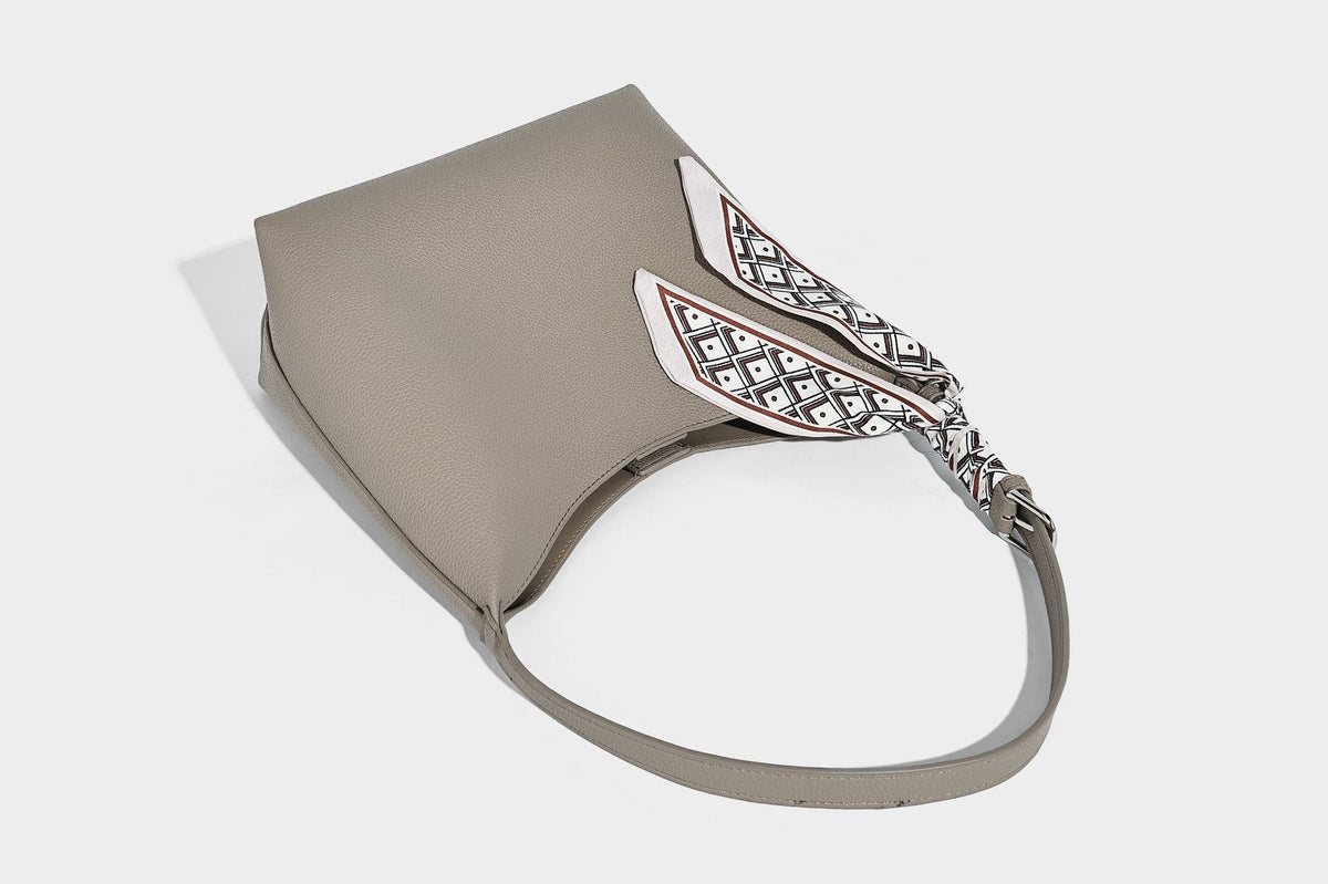 Soft slouchy hobo shoulder bag in pebbled matte finish with slim strap, silver-tone ring hardware, and knotted printed scarf