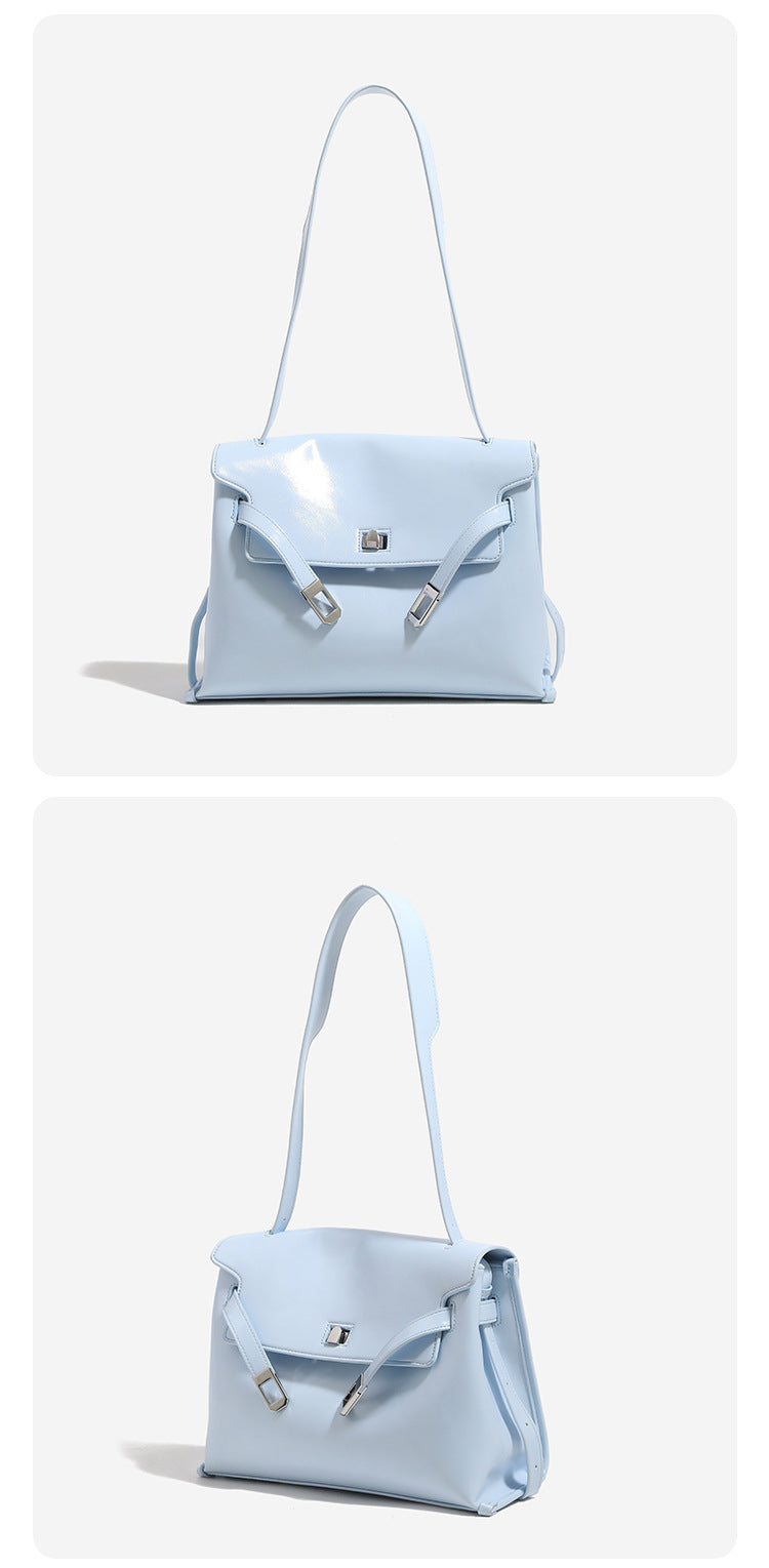 Structured rectangular flap shoulder bag in glossy leather-look finish with silver-tone turn-lock closure and adjustable