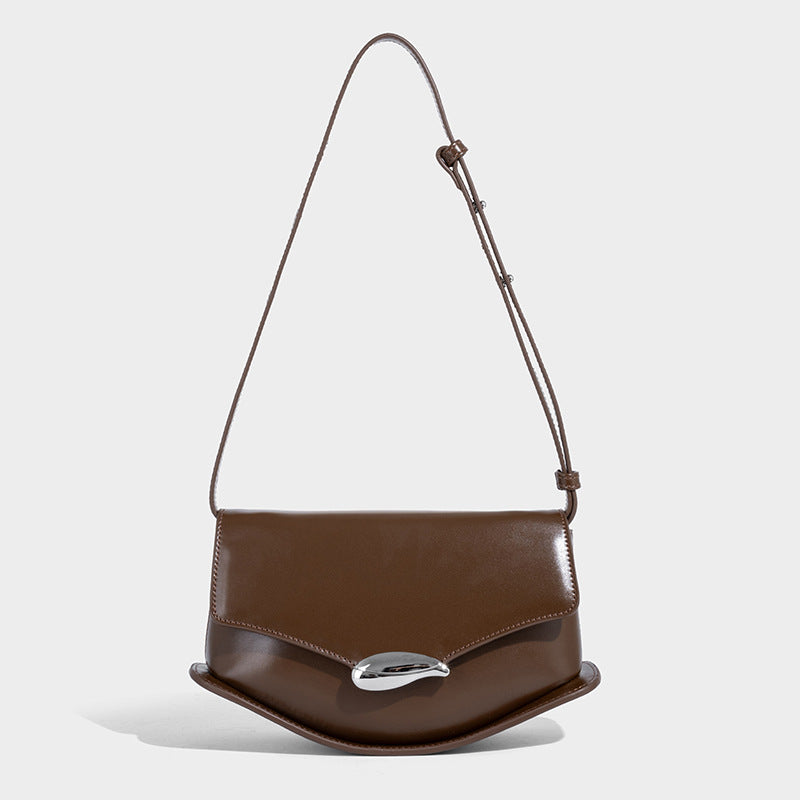 Small structured saddle bag with glossy leather-look finish, angular flap front, silver-tone metal clasp, and slim