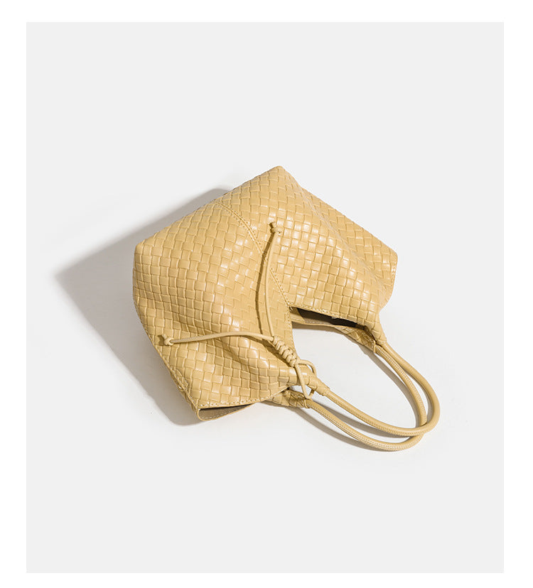 Weich strukturierte gewebte Tote-Bag in Gelbgold mit Lederoptik, V-förmiger offener Oberseite, seitlichen Kordeldetails und zwei röhrenförmigen