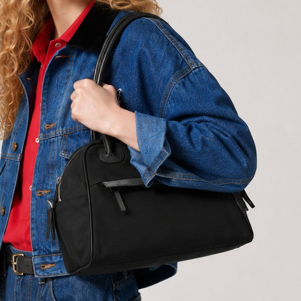 Structured dome top-handle bag in matte nylon with pebbled vegan leather-look trim, zip-top closure, front slip pocket, and