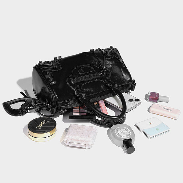 Glossy studded mini satchel bag with braided top handles, front zip pocket, heart charm, and detachable crossbody strap