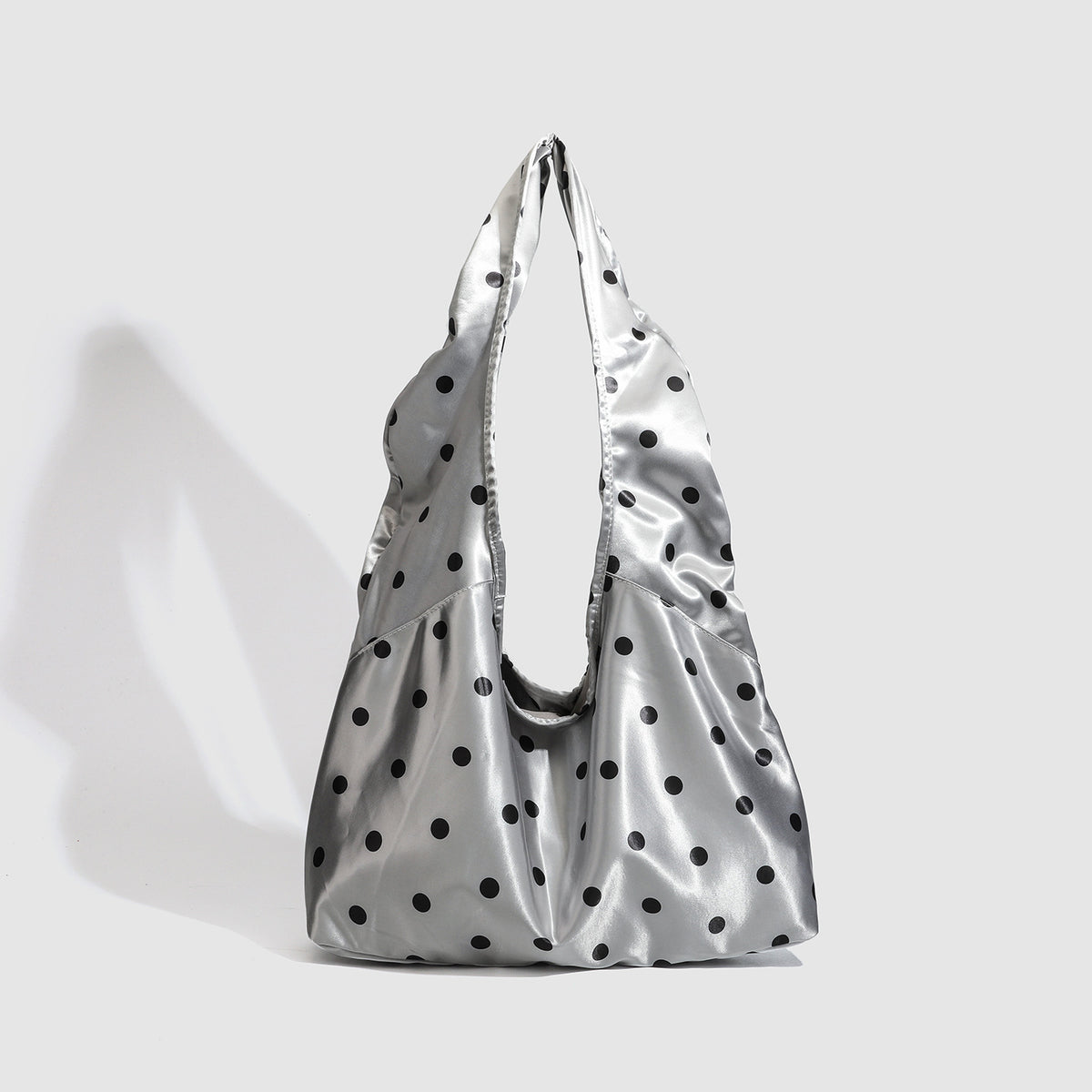 Ovale Tote-Schultertasche in silberfarbener Satinoptik mit schwarzem Punkteprint, Druckverschluss und langen integrierten Trägern, Detailansicht 6