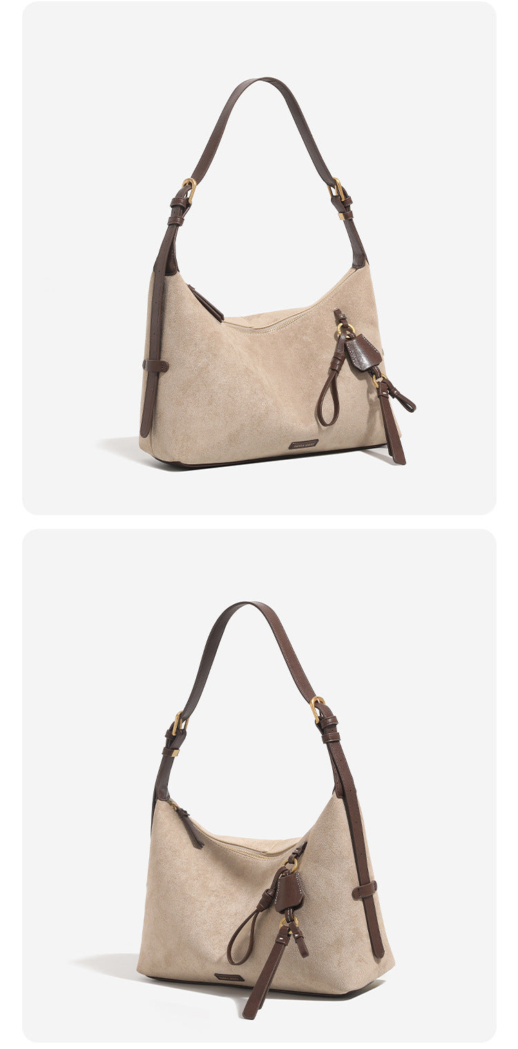 Hobo-Schultertasche in sandfarbener Velourslederoptik mit dunkelbraunen Riemen in Lederoptik, goldfarbenen Metalldetails, Reißverschluss oben und hängendem