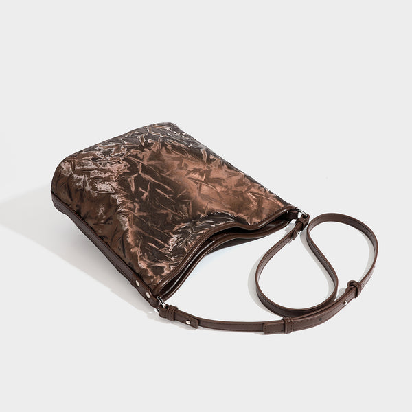 Große Hobo-Schultertasche mit Knitterglanz in tiefem Braun, schmalem verstellbarem Riemen, geknoteten Beschlägen und angesetztem seitlichem Überschlag