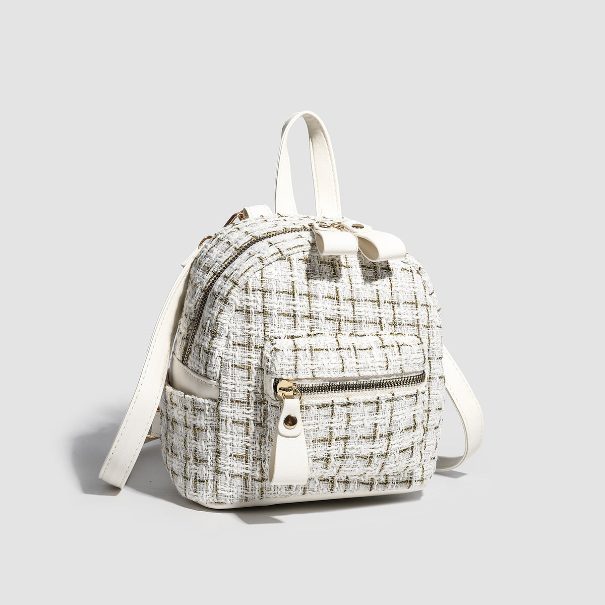 Small structured mini backpack in woven tweed-look fabric with gold-tone hardware and leather-look contrast trim, detail view