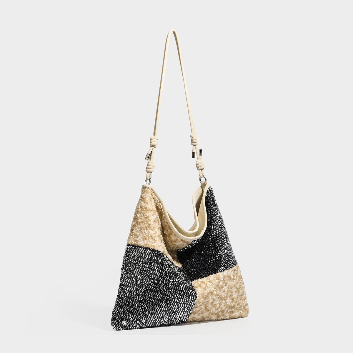 Slouchy hobo shoulder bag with black bugle-bead sequin and cream bouclé patchwork panels, adjustable cream leather-look