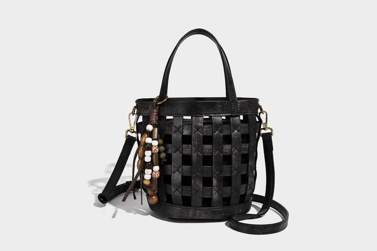 Small woven lattice bucket bag in brown leather-look finish with beaded tassel charm, dual top handles, and detachable