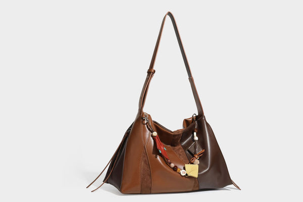 Two-tone black and brown leather-look slouchy shoulder bag with beaded tassel charm and silver-tone hardware, detail view 20