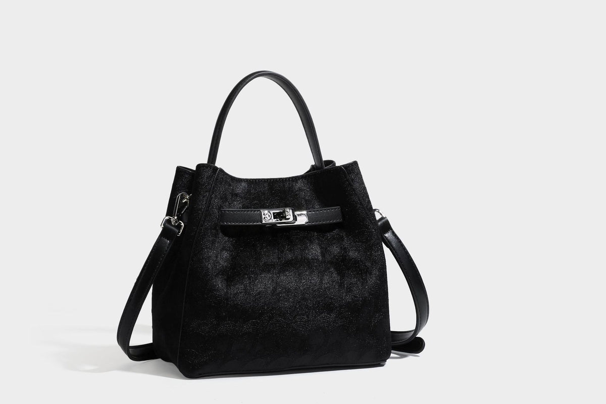 Small structured bucket satchel in embossed velvet-texture fabric with silver turn-lock hardware, rounded top handle, and