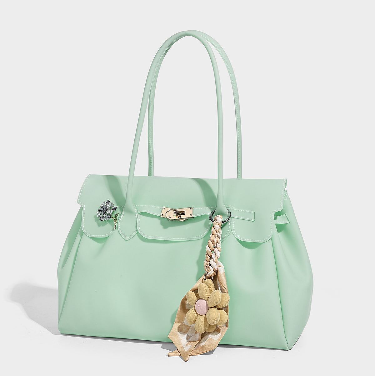 Strukturierte Tote-Bag aus mattem Jelly-Material mit goldfarbenem Klappverschluss mit Drehverschluss, zwei Schulterhenkeln, seitlichen Zwickeln und dekorativer