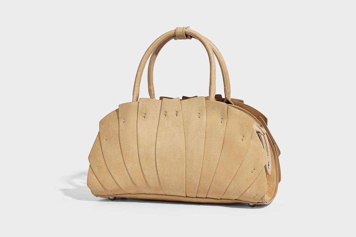 Structured dome satchel with fan-pleated leather-look exterior, dual top handles, and detachable shoulder strap, detail view