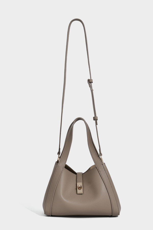 Structured trapezoid tote bag in taupe pebbled leather-look finish with gold-tone turn-lock hardware, dual top handles, and