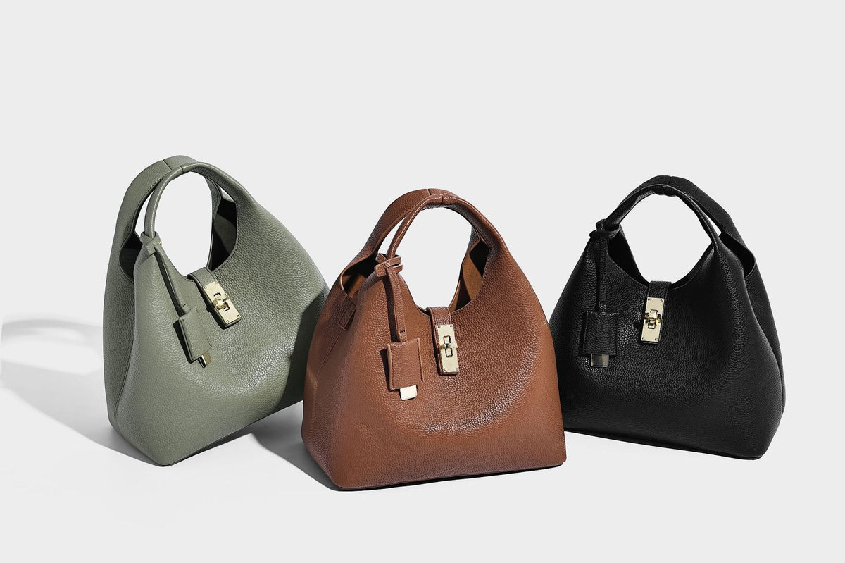 Structured pebbled-texture bucket bag with arched top handles, gold-tone turn-lock closure, and detachable shoulder strap