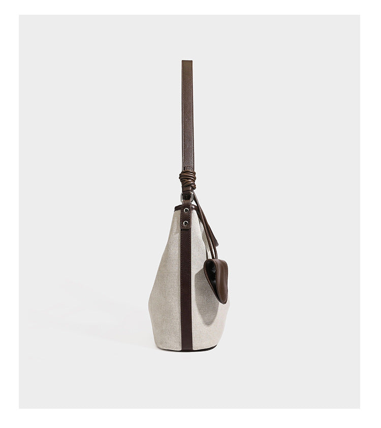 Schulter-Tote aus haferfarbenem Canvas mit dunkelbraunem Besatz in Lederoptik, langem verstellbarem Riemen und befestigtem Mini-Täschchen mit Klappe, Detailansicht