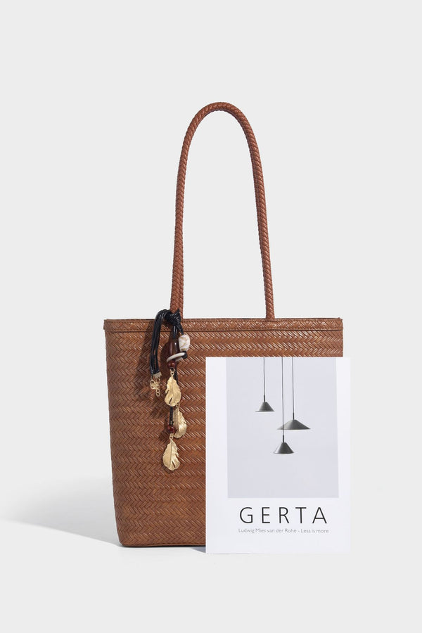 Structured woven herringbone tote bag with braided double shoulder handles in tan brown, shown with matching drawstring