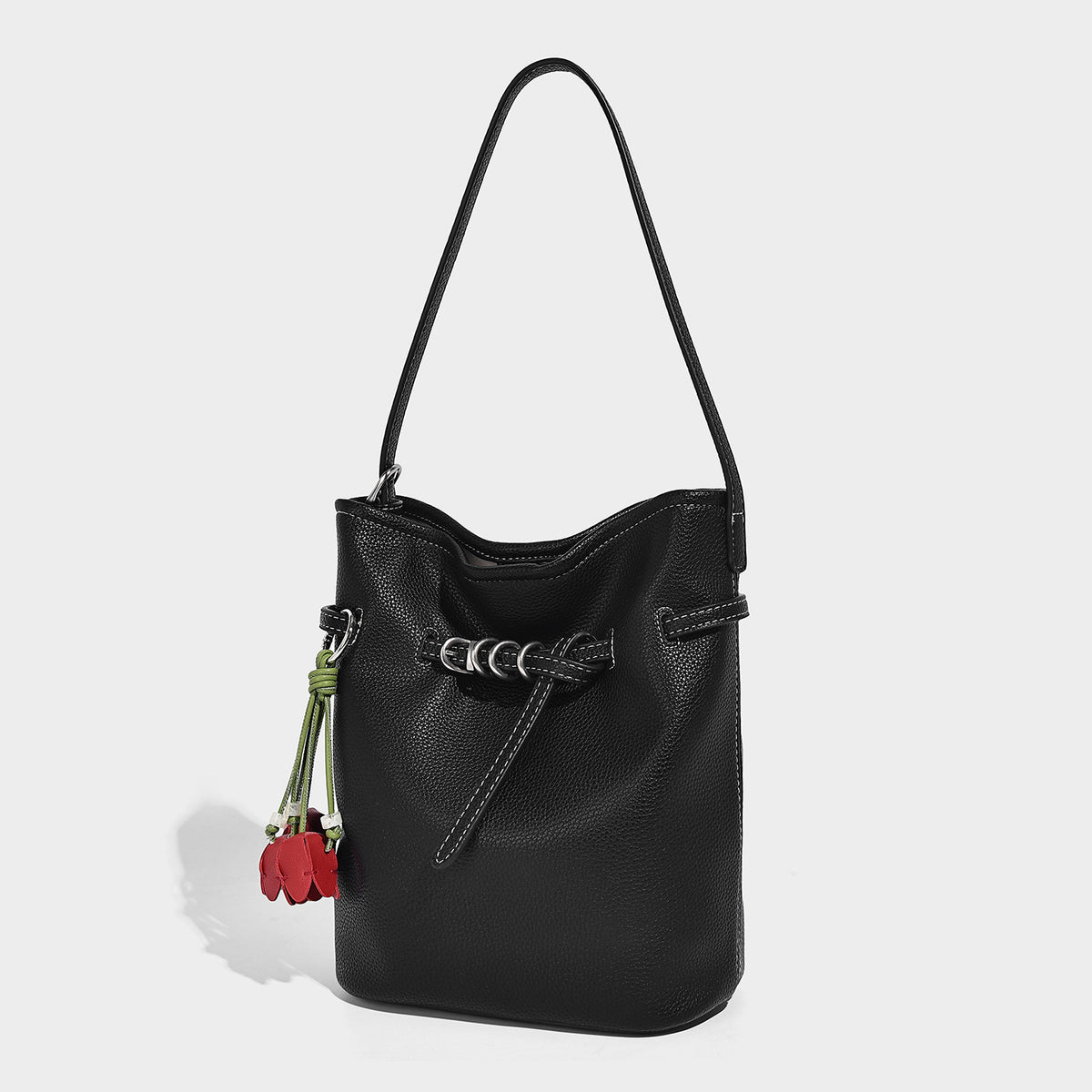 Small pebbled leather-look bucket bag with front drawstring toggle hardware and long adjustable shoulder strap, detail view 6