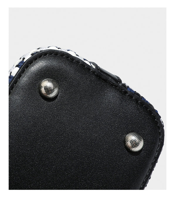 Small structured woven checker bucket bag with braided top handle, drawstring closure, and silver-tone hardware in black