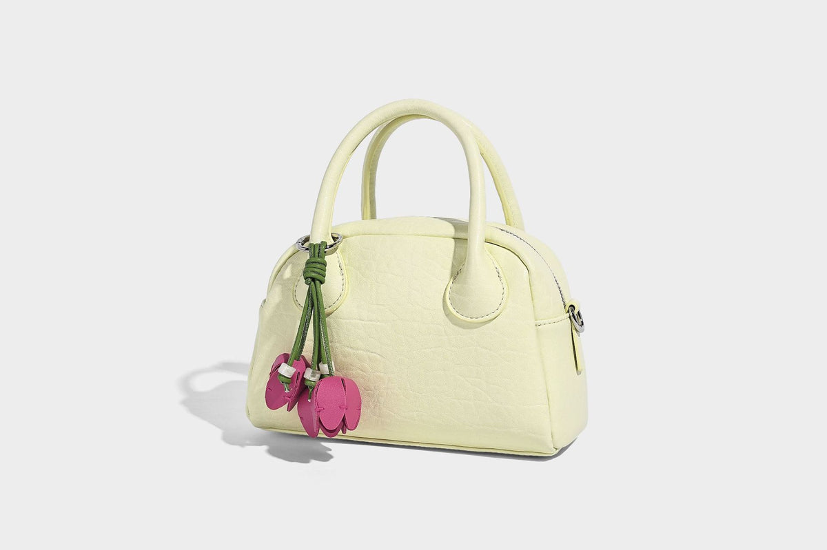 Mini-Henkeltasche in strukturierter Kuppelform in Pastellgelb mit genarbter Lederoptik, silberfarbenen Beschlägen und abnehmbarem