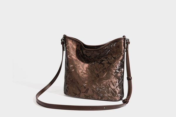 Große Hobo-Schultertasche mit Crinkle-Glanzfinish in Dunkelbraun, schmalem verstellbarem Riemen, geknoteten Beschlägen und seitlich befestigter Klappe