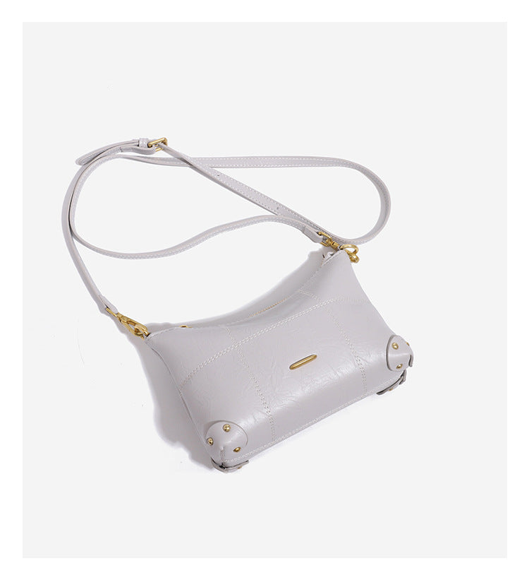 Small soft-structured shoulder bag with curved zip closure, stitched panel detailing, and gold-tone hardware, detail view 10
