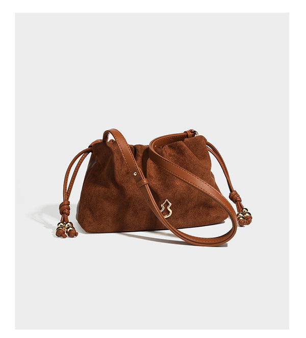 Suede-look drawstring shoulder bag in brown with smooth trim, knotted bead drawstring closure, slim adjustable strap, and