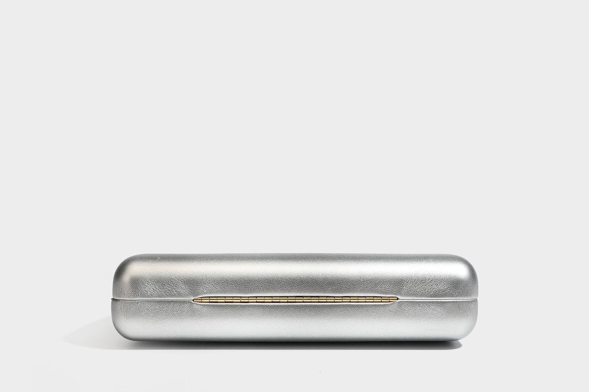 Strukturierte rechteckige Clutch mit goldfarbenem Henkel in Form einer Rosenknospe und abnehmbarem Kettenriemen in Metallic-Optik, Detailansicht
