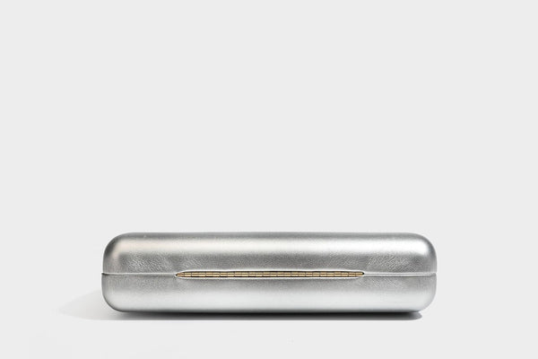 Strukturierte rechteckige Clutch mit goldfarbenem Henkel in Form einer Rosenknospe und abnehmbarem Kettenriemen in Metallic-Optik, Detailansicht