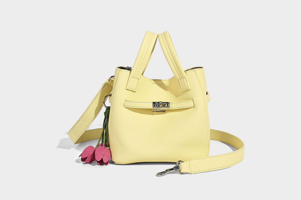 Small structured pebbled bucket tote bag with dual top handles, silver turn-lock front pocket, and detachable shoulder strap
