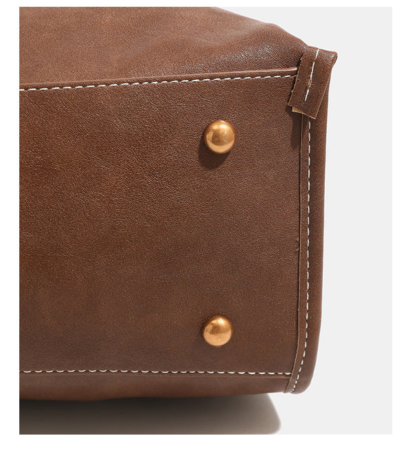 Structured leather-look flap backpack handbag with top handle, buckle front straps, white contrast stitching, and gold-tone