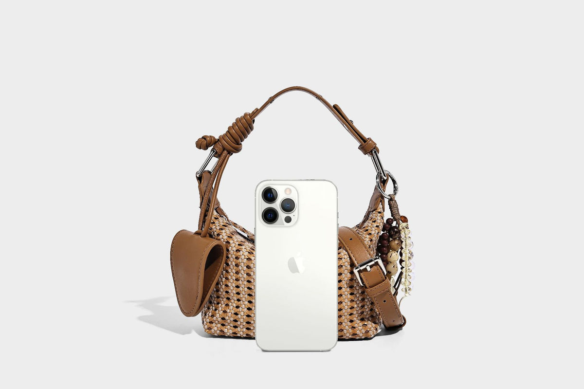 Woven crescent shoulder bag with leather-look knotted handle, zip top, attached mini pouch, and silver-tone hardware, detail