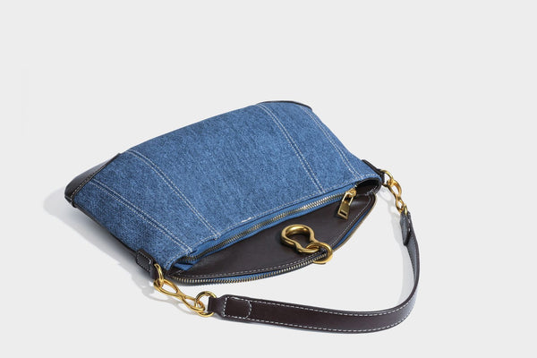 Slouchy denim shoulder bag with dark leather-look trim, gold-tone chain-link hardware, and top zipper closure, detail view 34