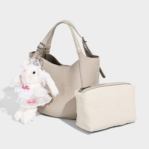 Small pebbled half-moon shoulder bag with dual top handles, detachable crossbody strap, and silver-tone hardware, front view