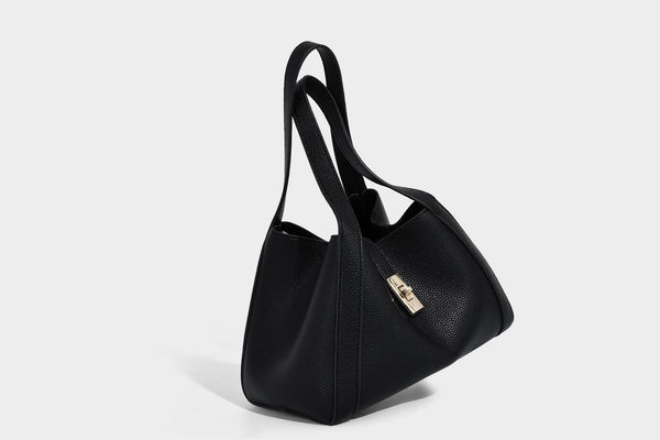 Structured trapezoid tote bag in taupe pebbled leather-look finish with gold-tone turn-lock hardware, dual top handles, and